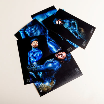 Seis fotos impresas sueltas del Sixpack de ErosGay (colección Oráculo, modelo FelixFox), extendidas y sobrepuestas en una superficie clara; predominan tonos azules intensos con fondo oscuro, mostrando distintos encuadres del modelo