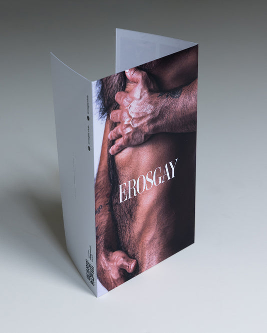 Empaque del Sixpack “Fulgor” de ErosGay (modelo Oscar), en vista a tres cuartos; portada a color con primer plano del torso masculino y manos cruzadas, con el logotipo “EROSGAY” al centro y un código QR en el lateral.