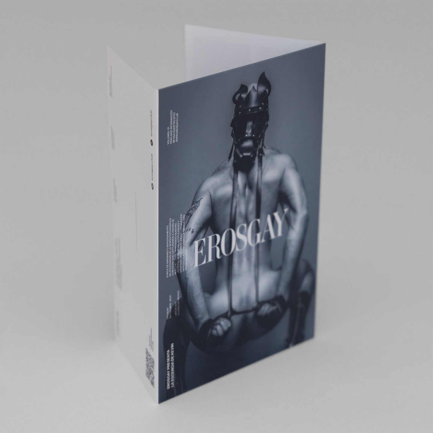 obre del Sixpack Kevin de ErosGay, vista 3/4: portada en blanco y negro con modelo en máscara de cuero y logo EROSGAY; lateral blanco con texto y código QR