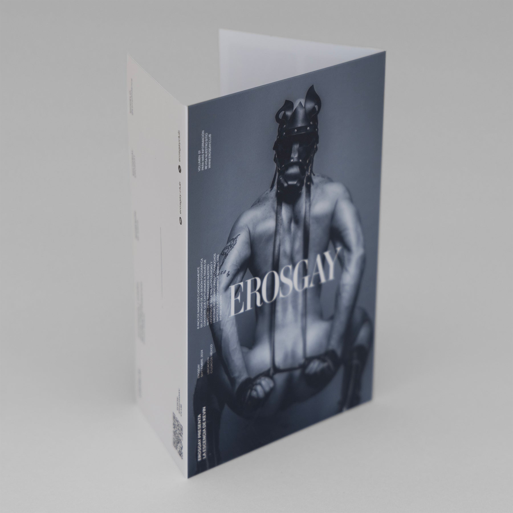 obre del Sixpack Kevin de ErosGay, vista 3/4: portada en blanco y negro con modelo en máscara de cuero y logo EROSGAY; lateral blanco con texto y código QR