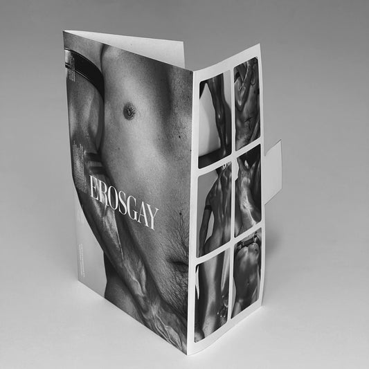 Sobre del sixpack de Lalo (ErosGay) fotografiado en blanco y negro, de pie sobre fondo gris claro y abierto en forma de ‘L’. En el frente se ve un close-up del torso masculino con el logotipo ‘EROSGAY’ al centro; en la solapa lateral aparece una cuadrícula con 6 miniaturas en blanco y negro como preview de las fotos incluidas. La pestaña de cierre sobresale hacia la derecha