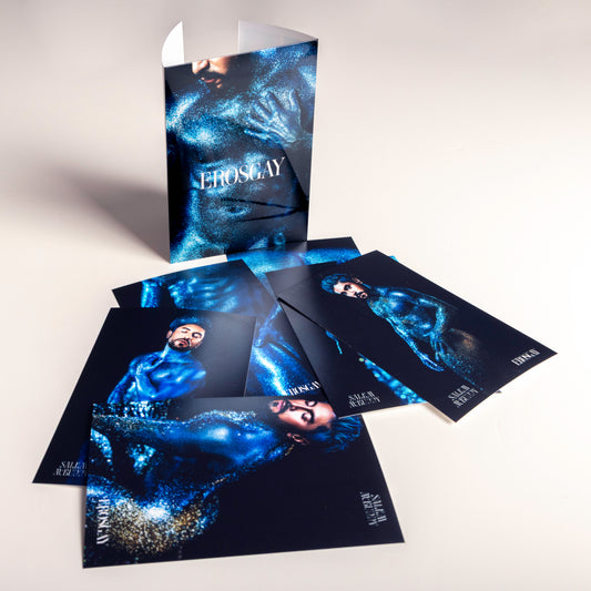 Sobre del producto Sixpack de ErosGay de la colección Oráculo (modelo FelixFox) de pie, con las 6 imágenes impresas extendidas a un lado sobre una superficie clara, mostrando el contenido completo del set